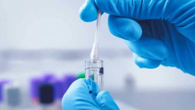 A imagem mostra as mãos de um profissional da saúde reservando em um tubo de ensaio a coleta de um exame de DNA.