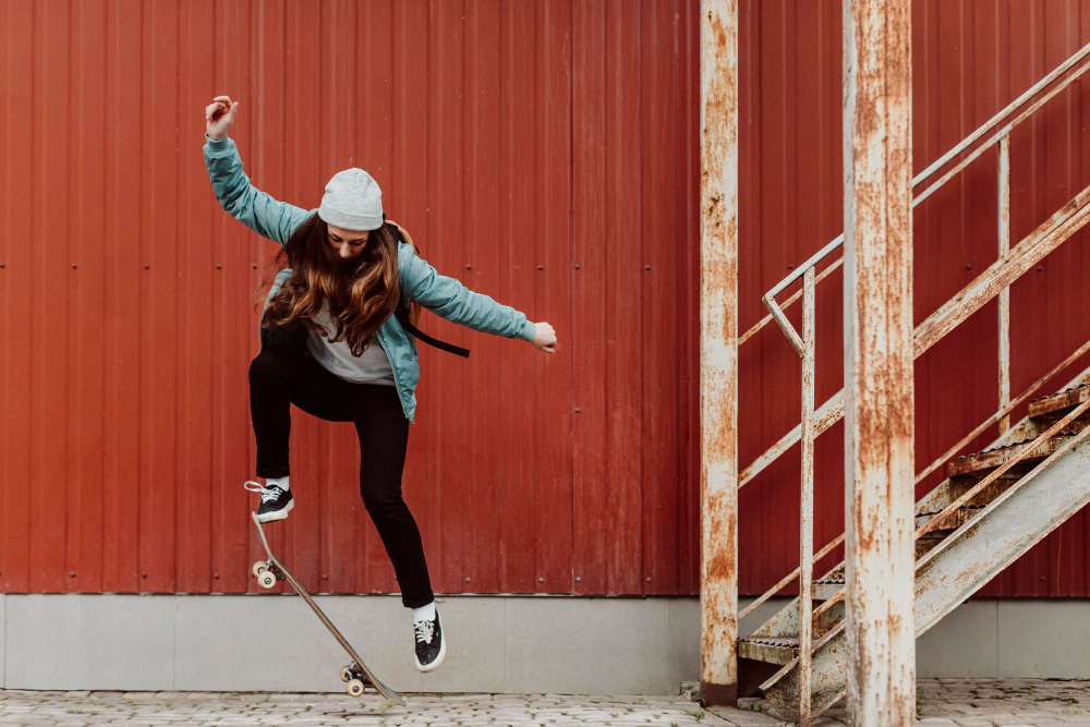 A imagem mostra uma mulher praticando manobras de skate.
