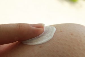Dedo passando protetor solar para previnir o cancer de pele