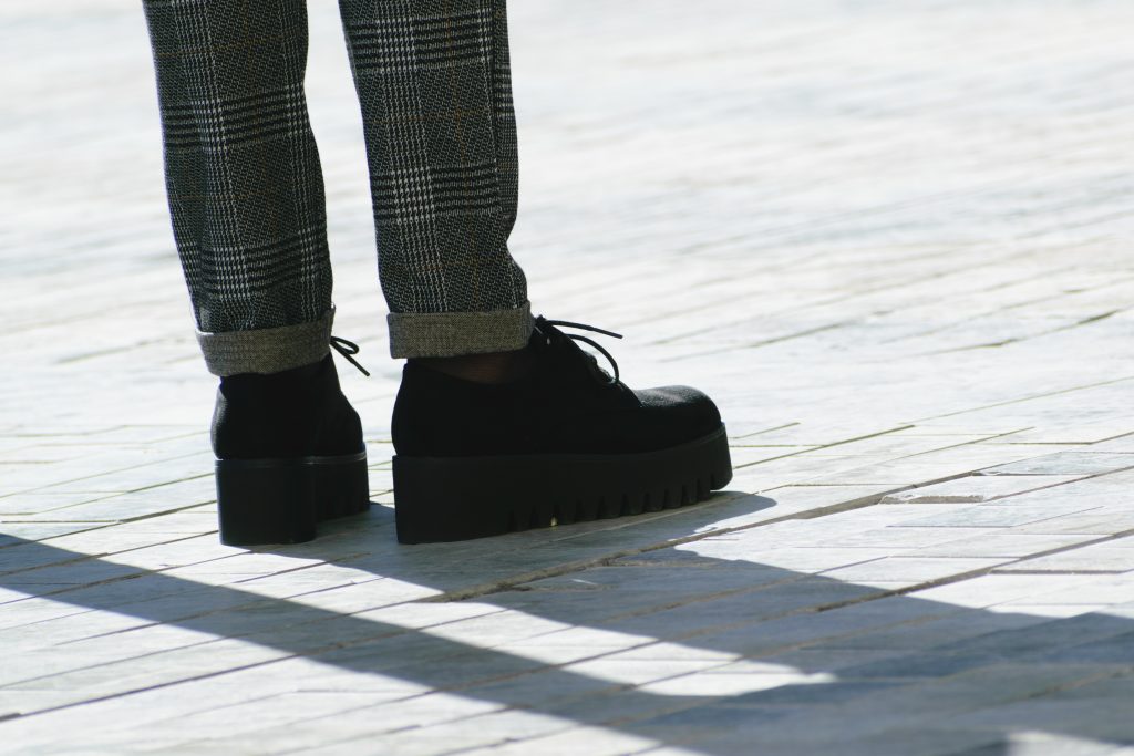 Pés de mulher com sapato plataforma preto. 